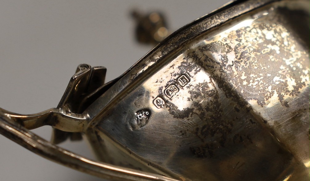 A George V silver four piece condiment set, by Adie Brothers, Birmingham, 1932 and two associated silver condiment spoons.